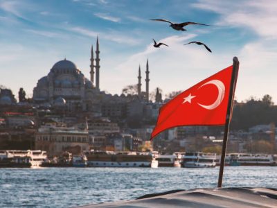 Turkish flag over Bosphorus boats, mosques, and minarets of Istanbul, Turkey